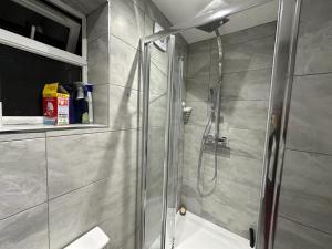 uma casa de banho com um chuveiro e uma porta de vidro em Cosy Smart/Small Double Room in Keedonwood Road Bromley em Bromley