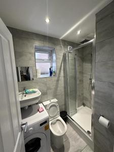 a bathroom with a toilet and a sink and a shower at Cosy Smart/Small Double Room in Keedonwood Road Bromley in Bromley