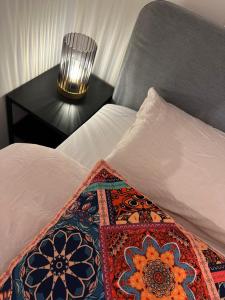 ein Bett mit einem Kissen und einer Lampe auf einem Tisch in der Unterkunft Chalet Quattro in bosrijke omgeving in Anloo