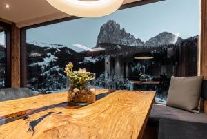 a dining room with a table and a large window at Enjoy Dolomites - Chalet in Santa Cristina Gherdëina