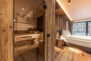Cabaña con dormitorio, cama y ventana en Enjoy Dolomites - Chalet, en Santa Cristina Valgardena