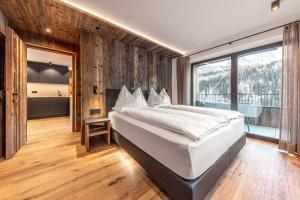 1 dormitorio con cama grande y ventana grande en Enjoy Dolomites - Chalet, en Santa Cristina Valgardena