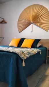 a bedroom with a bed with a fan on the wall at Tikazéla - Escale Tournon-Sur-Rhône in Tournon-sur-Rhône