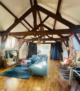 a living room with a blue couch in a room with wooden floors at Loft à partager in Seclin