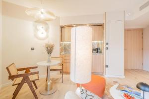 a living room with a table and a lamp at Yuna Porte-Maillot - ApartHotel in Paris