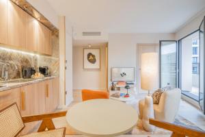 a living room with a table and a kitchen at Yuna Porte-Maillot - ApartHotel in Paris