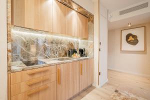 a kitchen with wooden cabinets and a sink at Yuna Porte-Maillot - ApartHotel in Paris