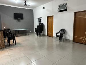 Habitación con sillas, mesa y TV. en Área de Lazer morada do sol, en São José do Rio Preto