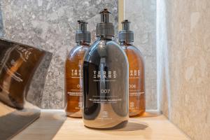 three bottles of alcohol are sitting on a shelf at Yuna Porte-Maillot - ApartHotel in Paris