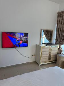 ein Schlafzimmer mit einem an der Wand hängenden TV in der Unterkunft Ft 30f R2 SeaView Room at Beach with separate bath in Ajman 