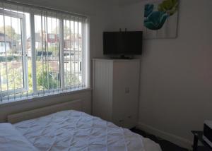 a bedroom with a bed and a flat screen tv at Fresher Space Home Stay in Birmingham