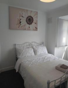 ein Schlafzimmer mit einem Bett mit einem Blumenbild an der Wand in der Unterkunft Fresher Space Home Stay in Birmingham