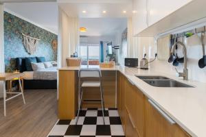 a kitchen and living room with a couch in the background at Cozy beach studio retreat near Lisbon with Sea View in Almada