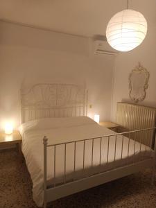 a bedroom with a white bed with two tables and a lamp at Villa Konstantina in Perani
