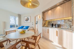 a kitchen and living room with a table and chairs at Yuna Porte-Maillot - ApartHotel in Paris