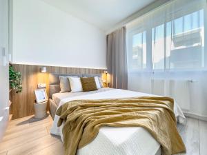 um quarto com uma cama grande e uma janela grande em Krakowska Oaza Komfortu - Apartament Premium z Garażem em Cracóvia
