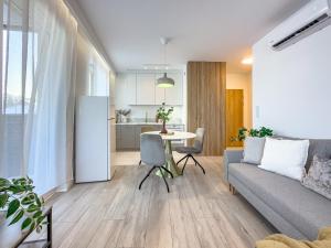 uma sala de estar com um sofá e uma mesa em Krakowska Oaza Komfortu - Apartament Premium z Garażem em Cracóvia