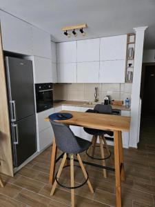 a kitchen with a wooden table and two chairs at Studio Leone Sunčana Planina in Kopaonik