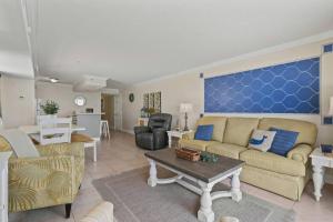 uma sala de estar com um sofá e uma mesa em Oceans At The Grove By Hostique em Myrtle Beach