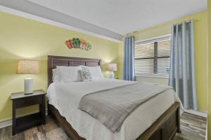 um quarto com uma cama grande e uma janela em Oceans At The Grove By Hostique em Myrtle Beach