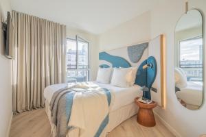 a hotel room with a bed and a mirror at Yuna Porte-Maillot - ApartHotel in Paris