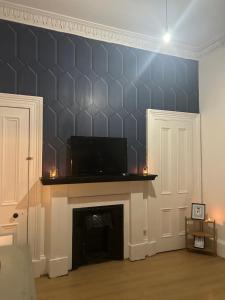 a living room with a fireplace with a black wall at Alexander Greek Thomson Apartment in Glasgow