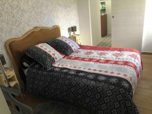 uma cama com um cobertor em cima em Au bord du gave em Laruns