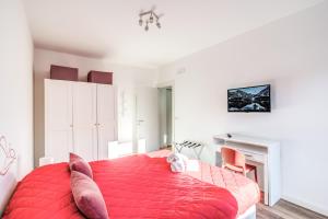 COSY FLAT CINECITTA' في روما: غرفة نوم بسرير احمر وموقد