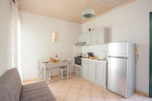 a kitchen with a stainless steel refrigerator and a table at Romanza Studios in Vasiliki