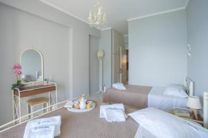 a bedroom with two beds and a desk and a mirror at Romanza Studios in Vasiliki