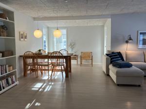 een woonkamer met een tafel en stoelen en een bank bij GuestHouse Læsø in Vesterø Havn