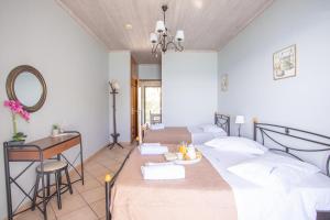 a bedroom with two beds and a desk and a mirror at Romanza Studios in Vasiliki