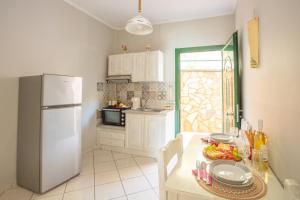 a kitchen with a white refrigerator and a table with food at Romanza Studios in Vasiliki
