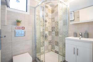 a bathroom with a shower and a toilet and a sink at Romanza Studios in Vasiliki