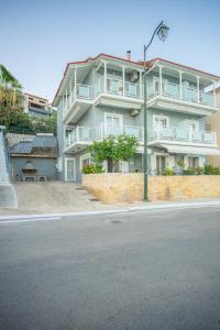 a large white building on the side of a street at Romanza Studios in Vasiliki