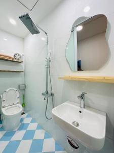 a bathroom with a sink and a toilet and a mirror at RARE 200m2 4BR Private house @ Hoan Kiem 13pax in Hanoi