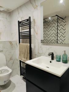 een witte badkamer met een wastafel en een toilet bij Bright & Cozy Appartment in Brussels in Brussel
