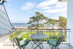 d'un balcon avec une table et des chaises donnant sur l'océan. dans l'établissement Villa Carmen, à Bansin