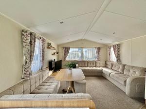 a large living room with couches and a table at Haven Seashore Holiday Park in Caister-on-Sea