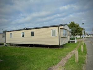 a large yellow house on the side of a road at Haven Seashore Holiday Park in Caister-on-Sea