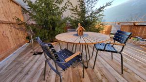 une table et des chaises en bois sur une terrasse en bois dans l'établissement Chalet Eden Vanoise, à Bourg-Saint-Maurice