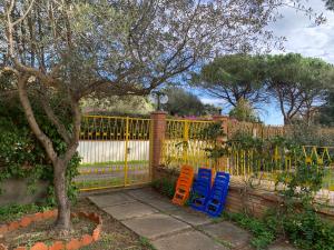 due sedie colorate sedute di fronte a una recinzione di Villa Gialla IUN Q5511 a Pula