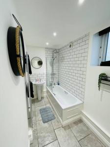 a white bathroom with a tub and a sink at Ground floor entire costal apartment in Watchet. in Watchet