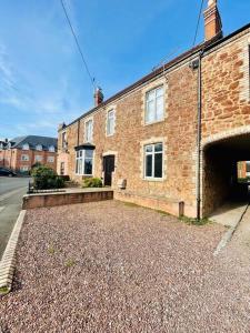 a brick building with a parking lot in front of it at Ground floor entire costal apartment in Watchet. in Watchet
