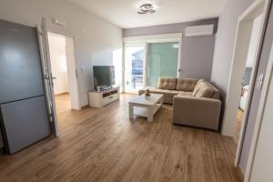 a living room with a couch and a table at Apartmani Lauc in Ljubuški