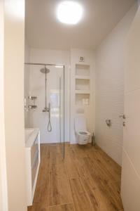 a bathroom with a shower and a toilet and a sink at Apartmani Lauc in Ljubuški