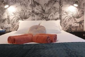 a bedroom with a bed with towels on it at Evasion Olympique Paris-Disney, charme et sérénité in Ozoir-la-Ferrière