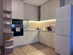 a kitchen with white cabinets and a white refrigerator at Cappuccino apartment in Sofia