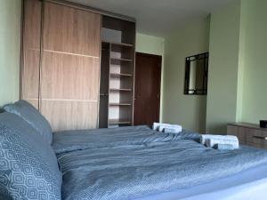 a bedroom with a blue bed with a wooden cabinet at Cappuccino apartment in Sofia