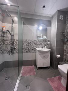 ein Bad mit einer Dusche, einem Waschbecken und einem WC in der Unterkunft Cappuccino apartment in Sofia